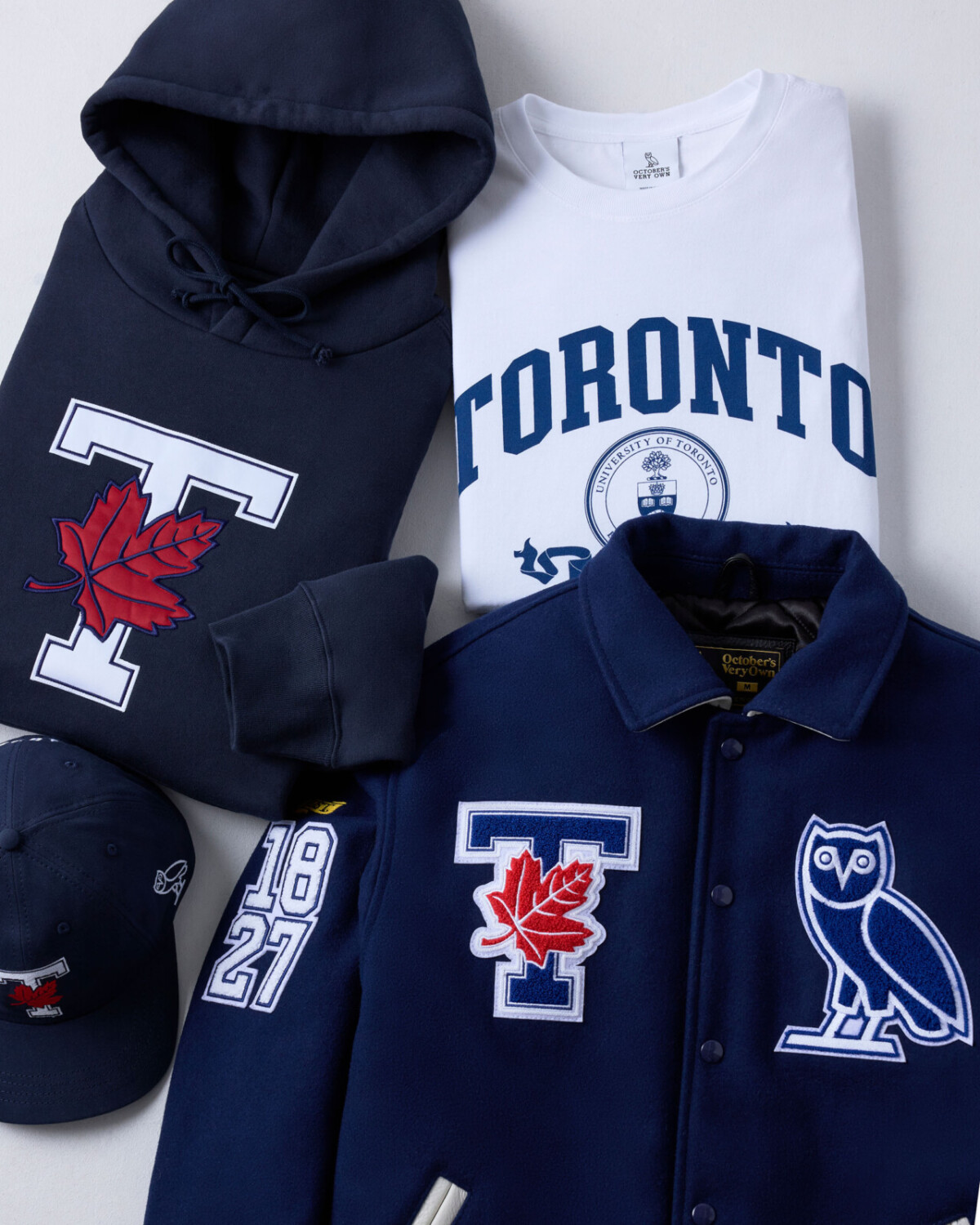 U of T OVO Fall 24 collection, jacket, hoody, t shirt and hat laid flat