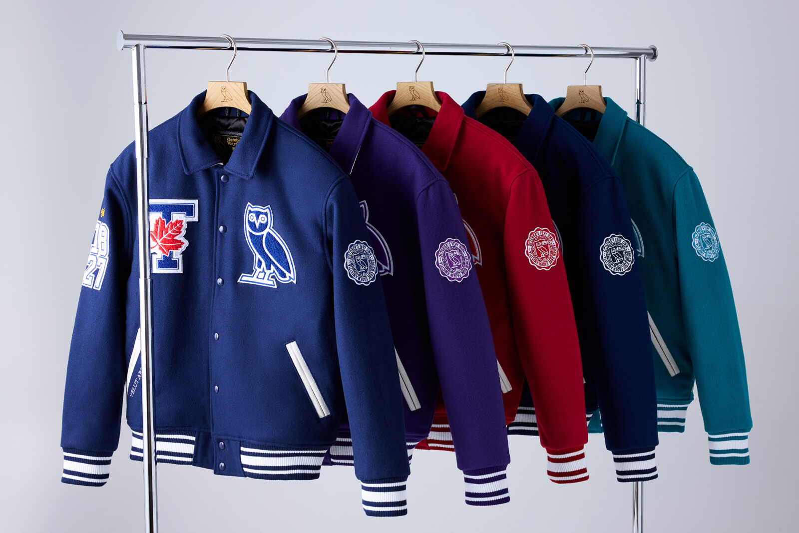 OVO Fall 2024 Varsity Jackets on a rolling rack with U of T in front followed by Western, Stanford, Yale and Cambridge